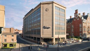 A modern building with a clock on the facade, a prominent entrance, and a surrounding urban street scene. - Malmaison York (York)