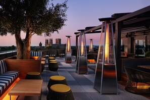 An outdoor seating area with modern furniture and a view of a historic building in the background.