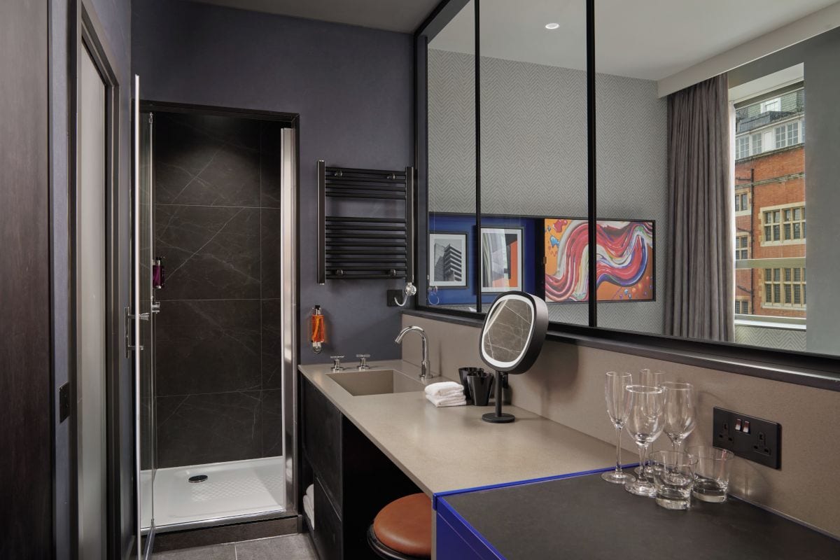 Un baño moderno con ducha, lavabo y espejo.