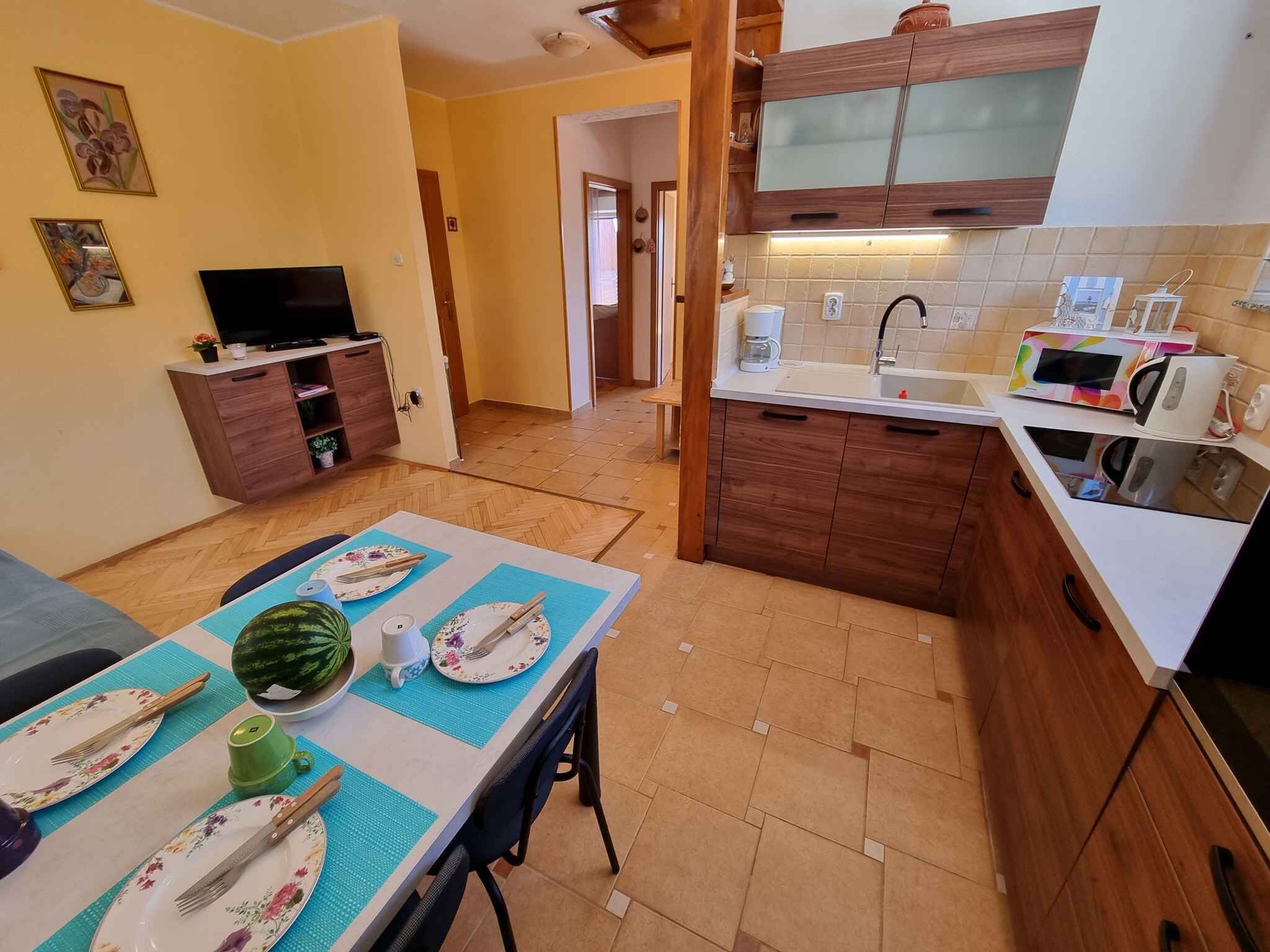 A compact living space with a dining area, a kitchenette, and a TV.