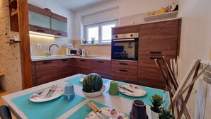 Eine moderne Küche mit Holzausstattung, einer Mikrowelle und einem Fenster.