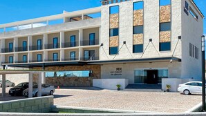 A modern hotel with a stone facade, multiple balconies, and a covered parking area. - Hotel MX más San Miguel de Allende (San Miguel de Allende)