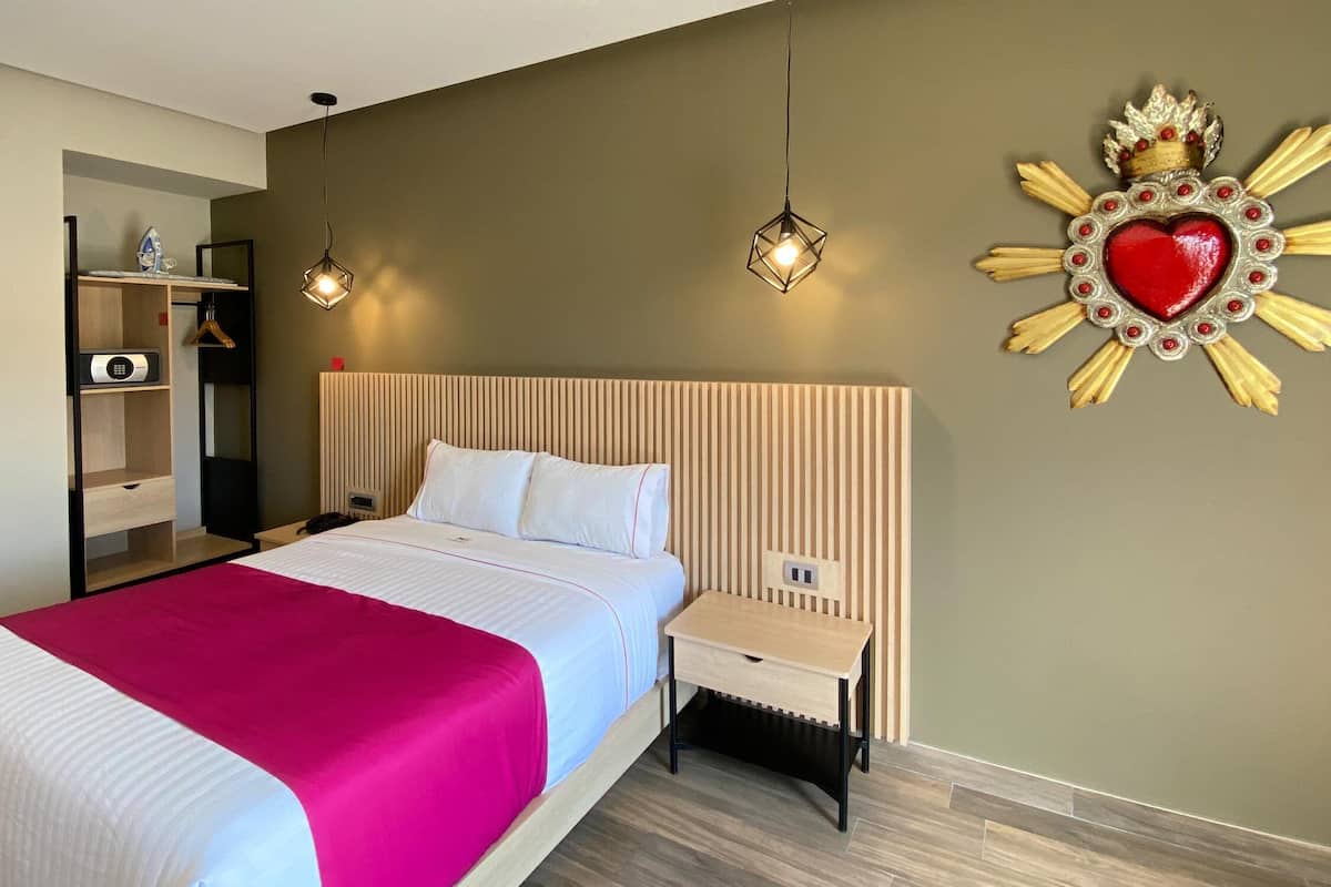 Une chambre d’hôtel avec un lit, une table de chevet et un élément décoratif mural.