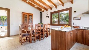 A kitchen with wooden cabinets, a dining table, and a large window.