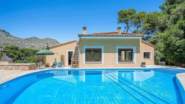 A swimming pool with a house in the background.