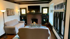 A living room with a fireplace, a sofa, a coffee table, and a lamp.