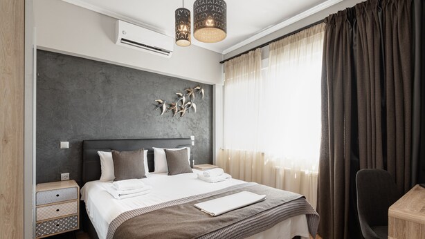 Une chambre d’hôtel moderne avec un grand lit, une table de chevet, une chaise et un bureau.