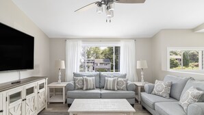 A living room with a grey sofa, a coffee table, and a TV on a cabinet.