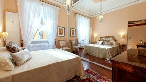 Ein Hotelzimmer mit zwei Betten, einer Kristallleuchter, einem Spiegel und einem Holztisch.