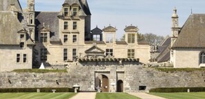 A historic stone building with a central entrance, multiple windows, and a symmetrical facade. - La Bâtisse du Dolmen Clara, Sleeps 15, Spa & Pool (PLOUNEVEZ LOCHRIST)