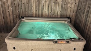 A hot tub with a wooden fence in the background.
