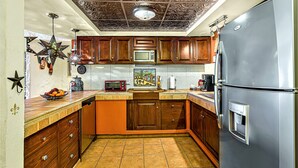 Una cocina con armarios de madera, un refrigerador de acero inoxidable, un microondas y una lámpara con forma de estrella.