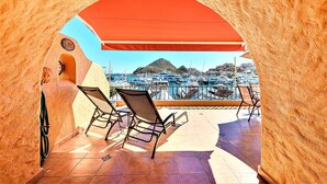 Un área de estar al aire libre con vista a un puerto deportivo y una montaña.