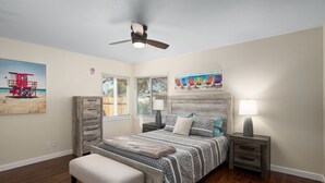 A bedroom with a bed, a bench, a nightstand, a ceiling fan, and artwork on the walls. - Upgraded 3B/2Bth w DinningR on Peaceful Street (Fresno)