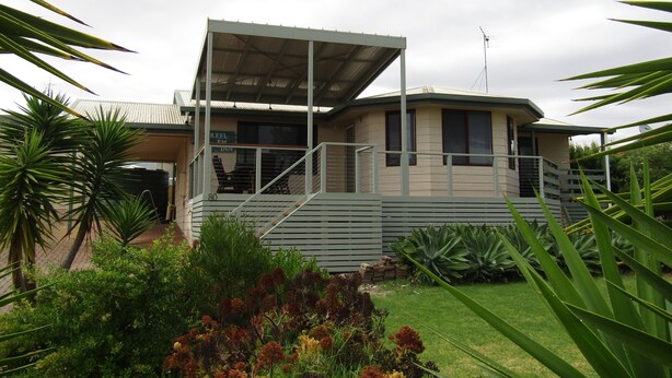 A two-story building with a covered outdoor area, a sign indicating a 'Reel FM Inn', and a number '80' on the side. - Reel Em Inn - Esplanade position.  Winter off peak special! (Point Turton)