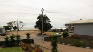 A residential area with a view of the sea, a paved road, and a white car parked on the street. - Reel Em Inn - Esplanade position.  Winter off peak special! (Point Turton)