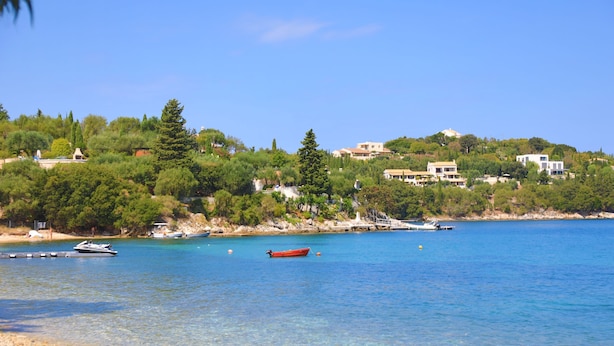 A coastal scene with clear waters, boats, and buildings on a hillside. - Fishermans Cottage: Private pool, a/c, near beach (Avlaki)