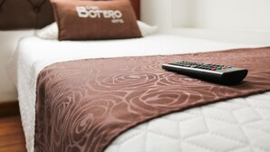 Una cama con una manta marrón y un control remoto.