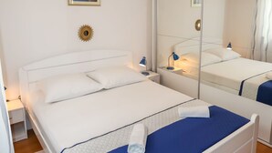 A neatly arranged bedroom with a large mirror, a bedside lamp, and a painting on the wall. - Nice apartment for 4 people with A/C, WIFI, TV and terrace (Solin)