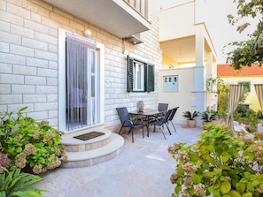 A courtyard with a stone floor, outdoor seating, and potted plants. - Lovely apartment for 5 guests with A/C, WIFI, TV and balcony (Solin)