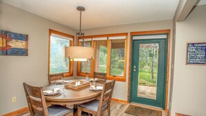 A dining area with a wooden table, chairs, and a hanging light fixture. - Ski Keystone, Spacious Ground Floor Condo with Meadow Views &  Resort Amenities! (Keystone)