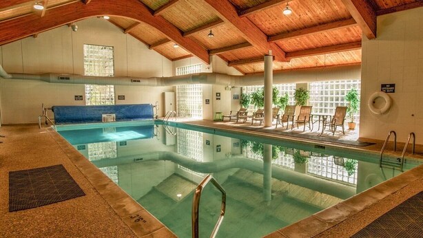 An indoor swimming pool with wooden beams, lounge chairs, and a tiled wall. - Ski Keystone, Spacious Ground Floor Condo with Meadow Views &  Resort Amenities! (Keystone)