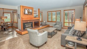 A spacious living room with a fireplace, large windows, and a cozy seating area. - Ski Keystone, Spacious Ground Floor Condo with Meadow Views &  Resort Amenities! (Keystone)