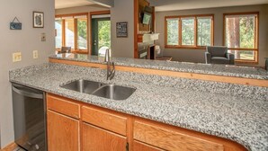 A kitchen with granite countertops, wooden cabinets, a stainless steel sink, and a built-in oven. - Ski Keystone, Spacious Ground Floor Condo with Meadow Views &  Resort Amenities! (Keystone)