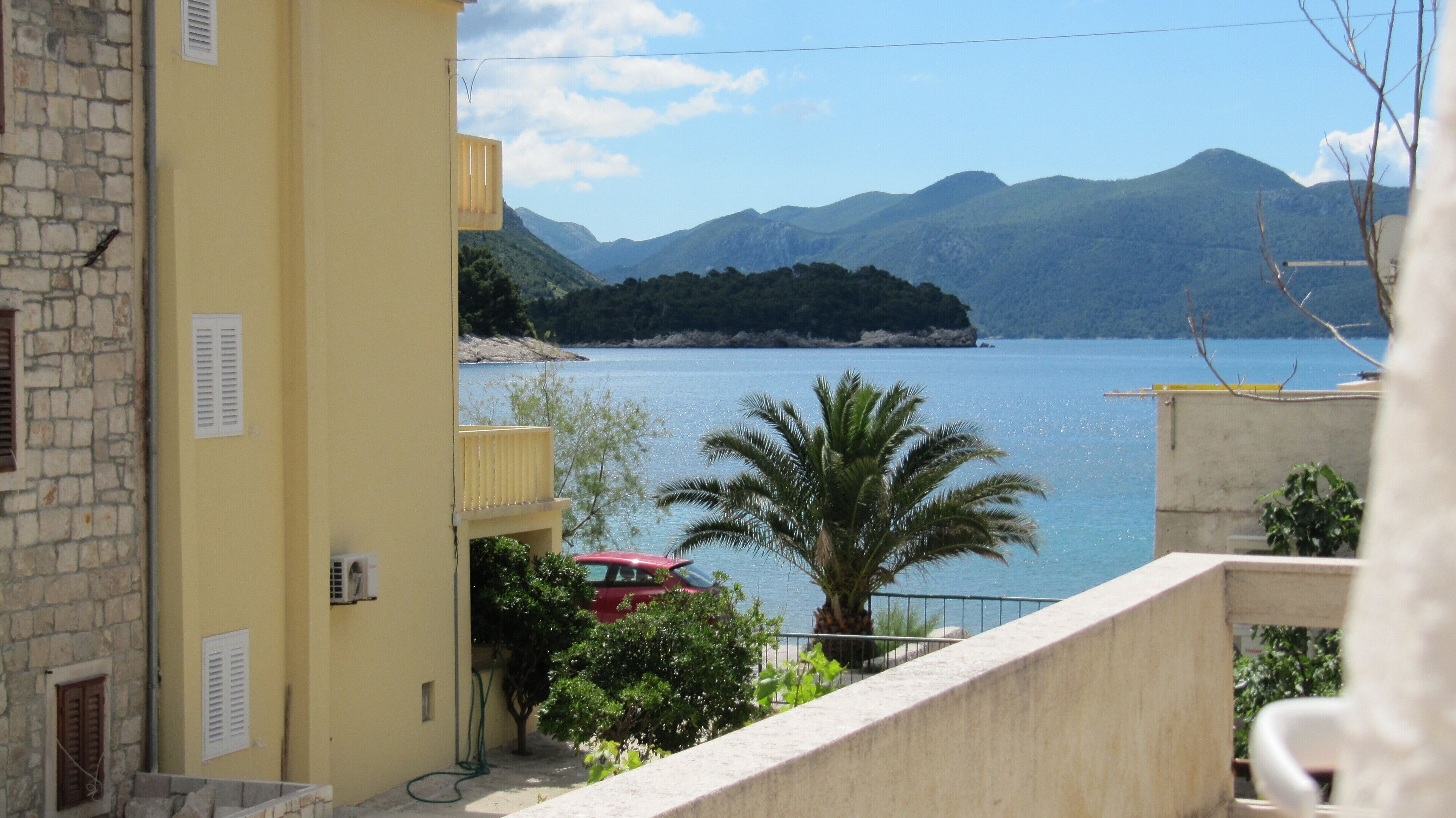 Ein Küstengebäude mit Blick auf das Meer und die Berge.