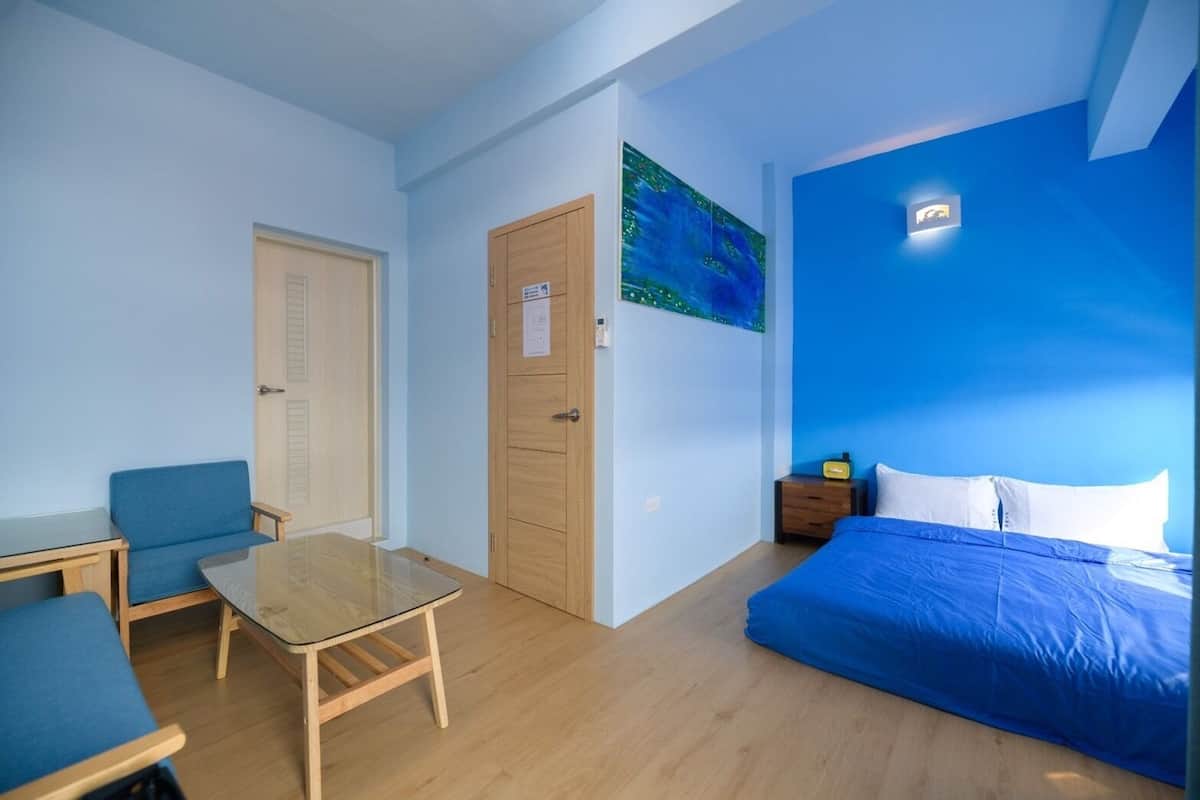 Une pièce comprenant un lit, un bureau, une chaise et un tableau accroché au mur.