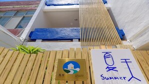 A wooden fence with a plaque and a sign that reads "Summer". - Summer Homestay (Magong)