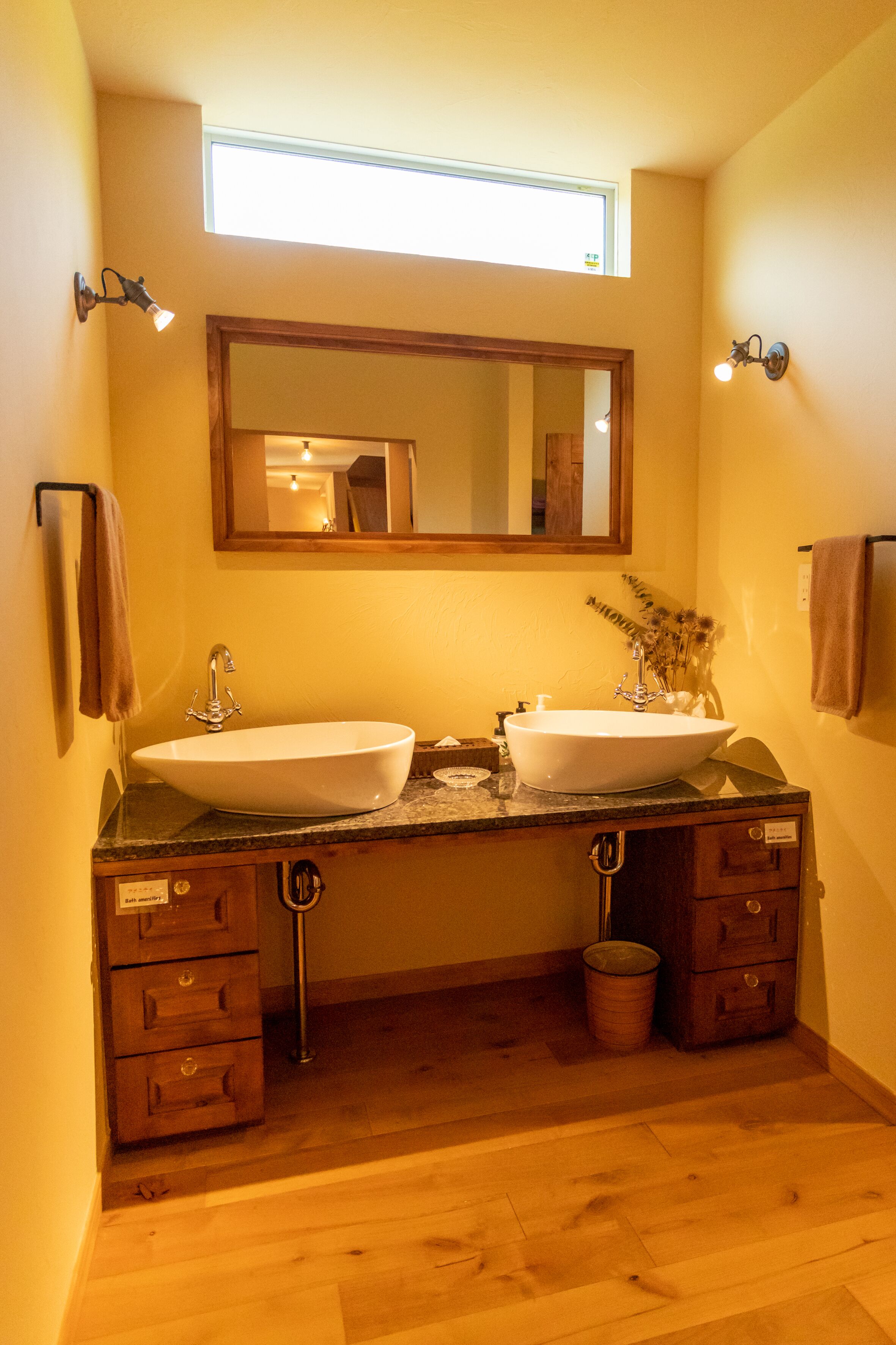 Ein Badezimmer mit zwei Waschbecken, einem großen Spiegel und Holzschränken.