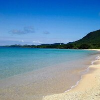 Una playa cerca, arena blanca, sombrillas, toallas de playa