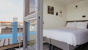 A bedroom with a bed, a window, and a view of a pool.