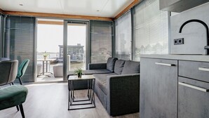 A modern interior with a sofa, a small table, and a kitchen area with a sink and cabinets.