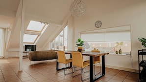 Un moderno apartamento tipo loft con comedor, un amplio ventanal y vistas a la ciudad.