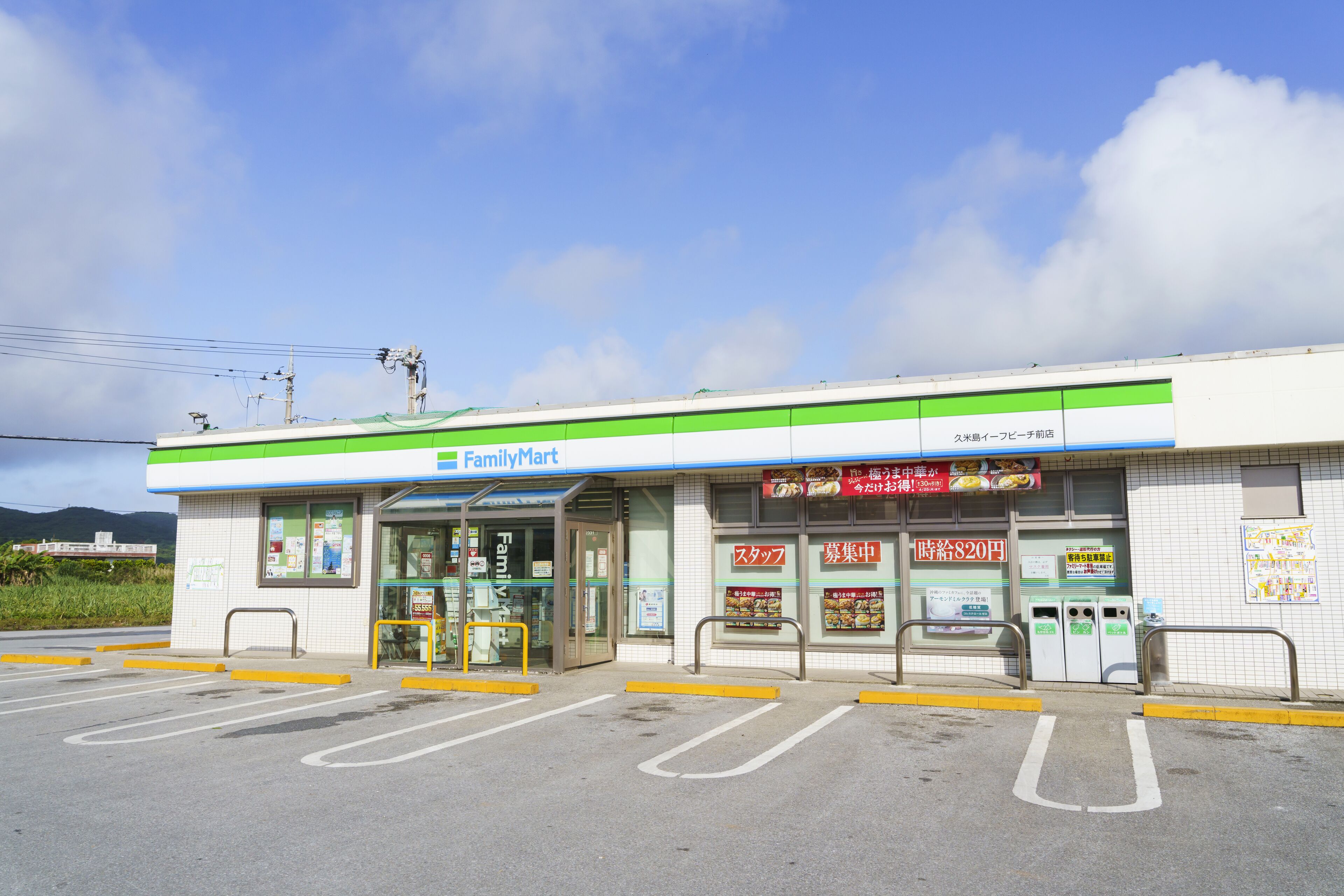 A FamilyMart store with a clear entrance, parking lot, and a sign indicating a 820 yen price for a product.
