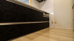 Une cuisine moderne avec des meubles de couleur sombre et un plancher en bois.