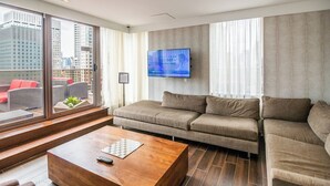Un saló modern amb un sofà, una taula de centre i un televisor fixat a la paret.