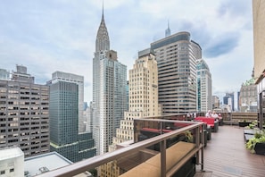 A rooftop terrace with a view of the city skyline, including a prominent skyscraper. - Manhattan | Grand Central City Base | Dining & Broadway (Manhattan)