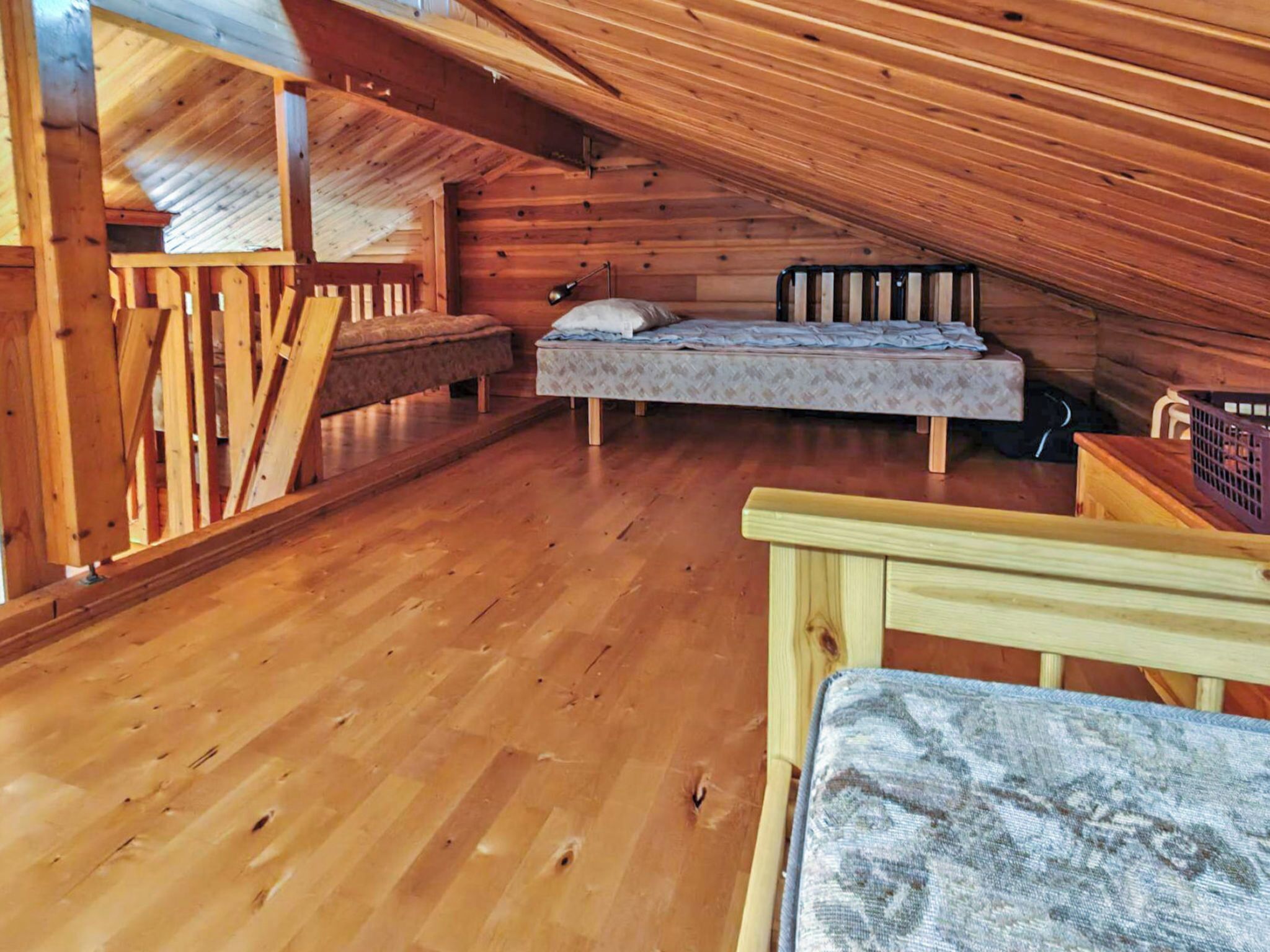 A wooden interior with a loft-style bed and a bench.