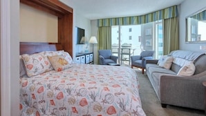 A hotel room with a bed, a sofa, a desk, and a chair. There is a window with curtains. - HS-1017 Ocean View Retreat on the 10th Floor in Myrtle Beach, Sleeps 6 (Myrtle Beach)