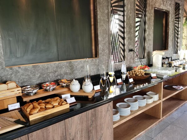 Un bufé con diversas opciones de comida, como pan, bollería y salsas.