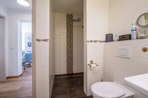 Tina, secadora de cabello, pantuflas, toallas 