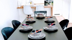 A dining table set with plates, bowls, and a centerpiece. - Charming Vacation Home “Ludwig der XVI” with Wi-Fi, Terrace & Garden (Schwandorf)