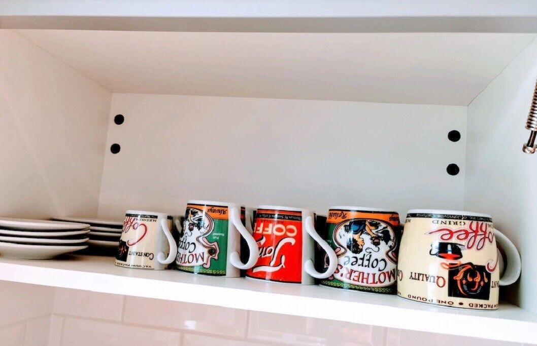 Ein Küchenregal mit einer Reihe Kaffeetassen und gestapelten Tellern.