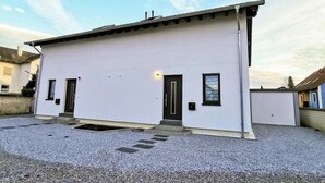 Un edifici blanc amb teulada plana, dues portes i una petita finestra.