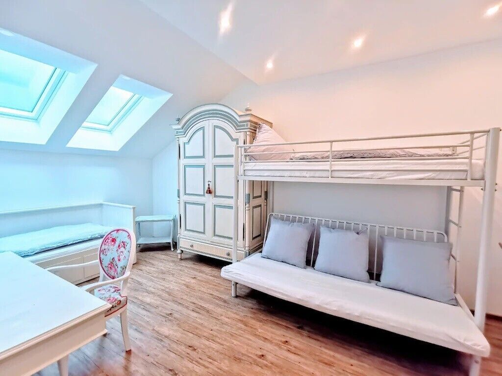 A room with a bunk bed, a desk, a chair, and a cabinet.