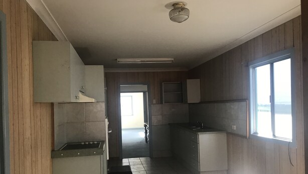 A kitchen with wooden paneling, a central island, and a window. - Camping with a Roof, bathroom and Kitchen (Palm Beach)