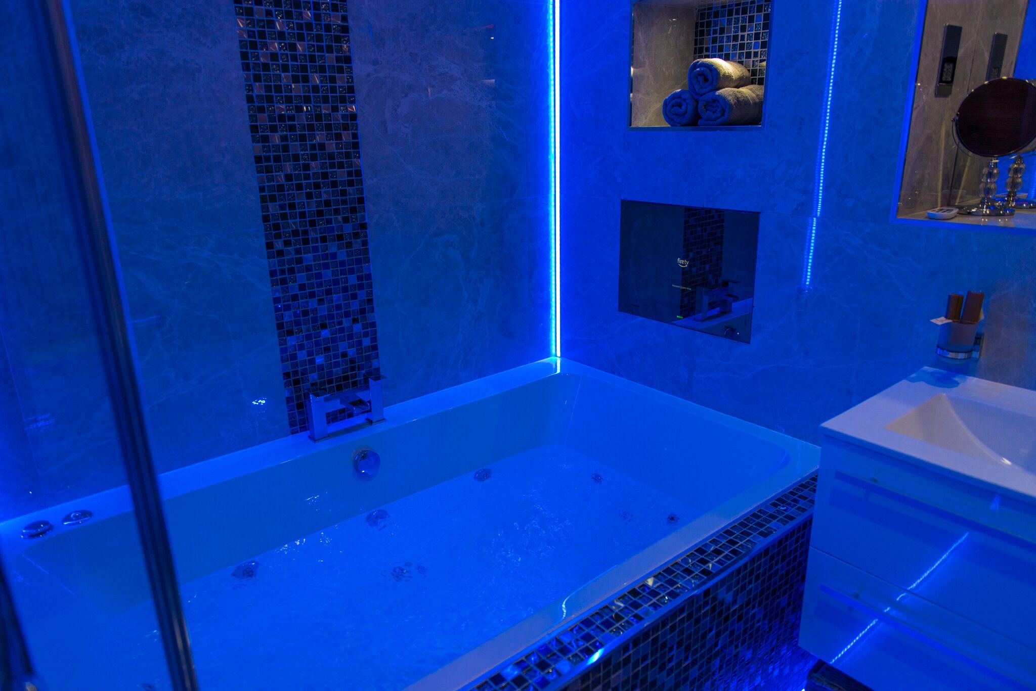 Une salle de bain moderne avec une grande baignoire, une douche à parois de verre et un meuble-lavabo avec un miroir.
